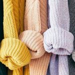 A rainbow of knitted long cardigans in white, green, yellow, peach, lilac, grey and blue