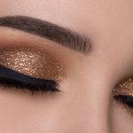 Woman with winged eyeliner and glittery eyeshadow