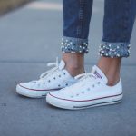 Woman wearing jewelled jeans and white Converse