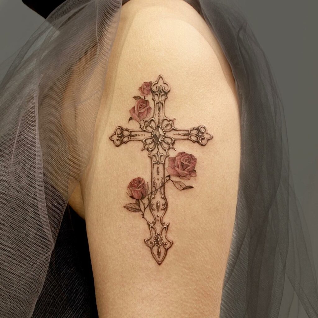 Black floral cross tattoo on inner lower arm for women