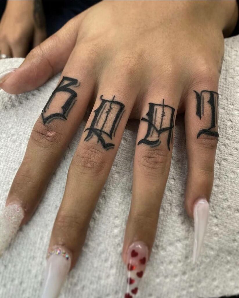 Fantastic Brat Lettering Tattoo on Fingers