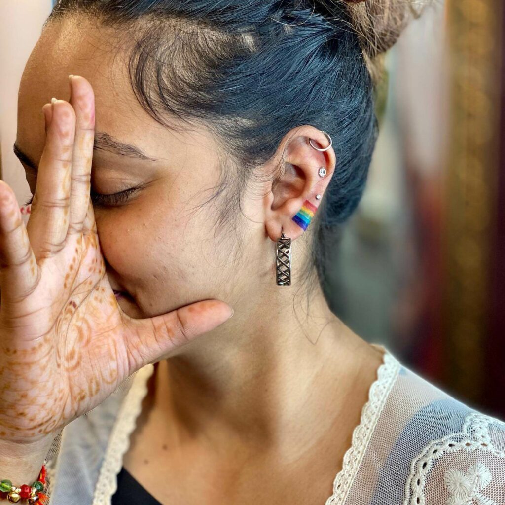 Micro rainbow tattoo done on the ear