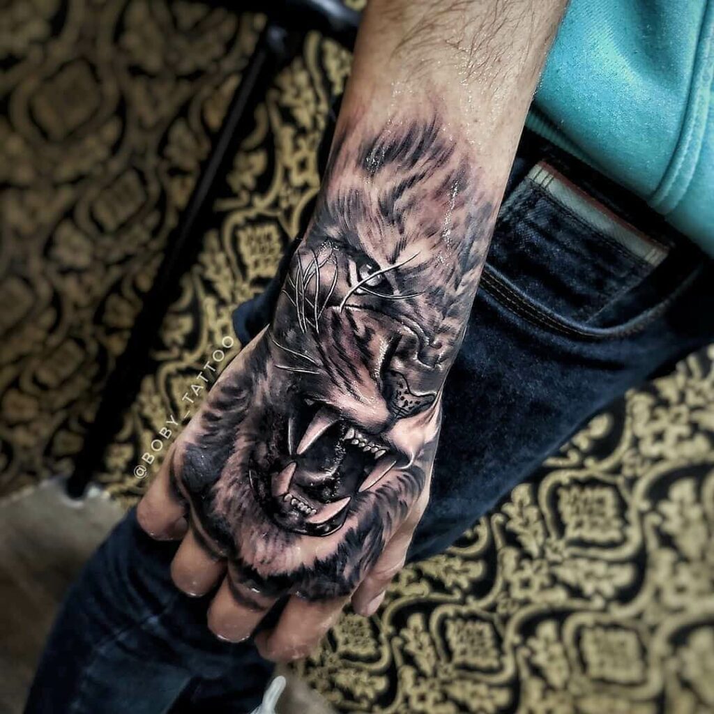 Lion On Hand Tattoo