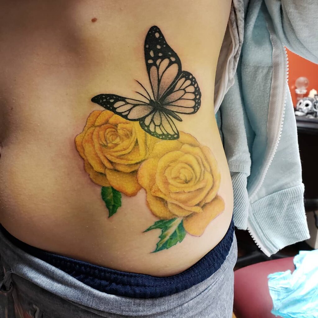 Aesthetic Yellow Roses Tattoo With A Monochromatic Butterfly On Top