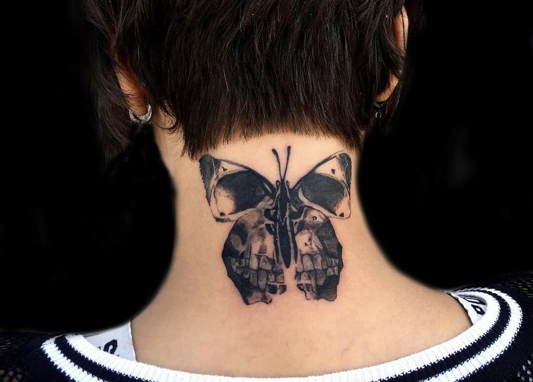 Skull butterfly tattoo on back of neck