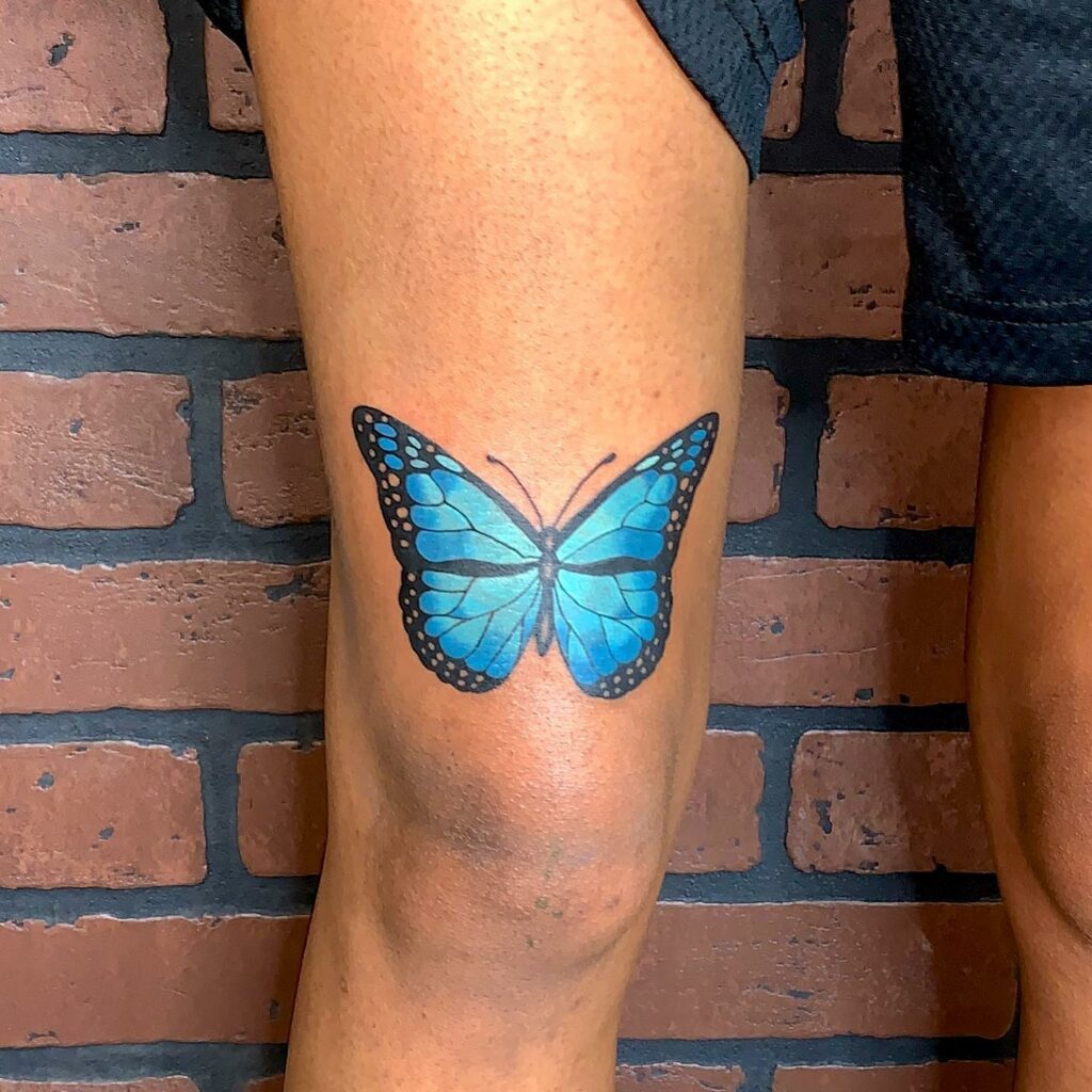 Blue butterfly tattoo on thigh