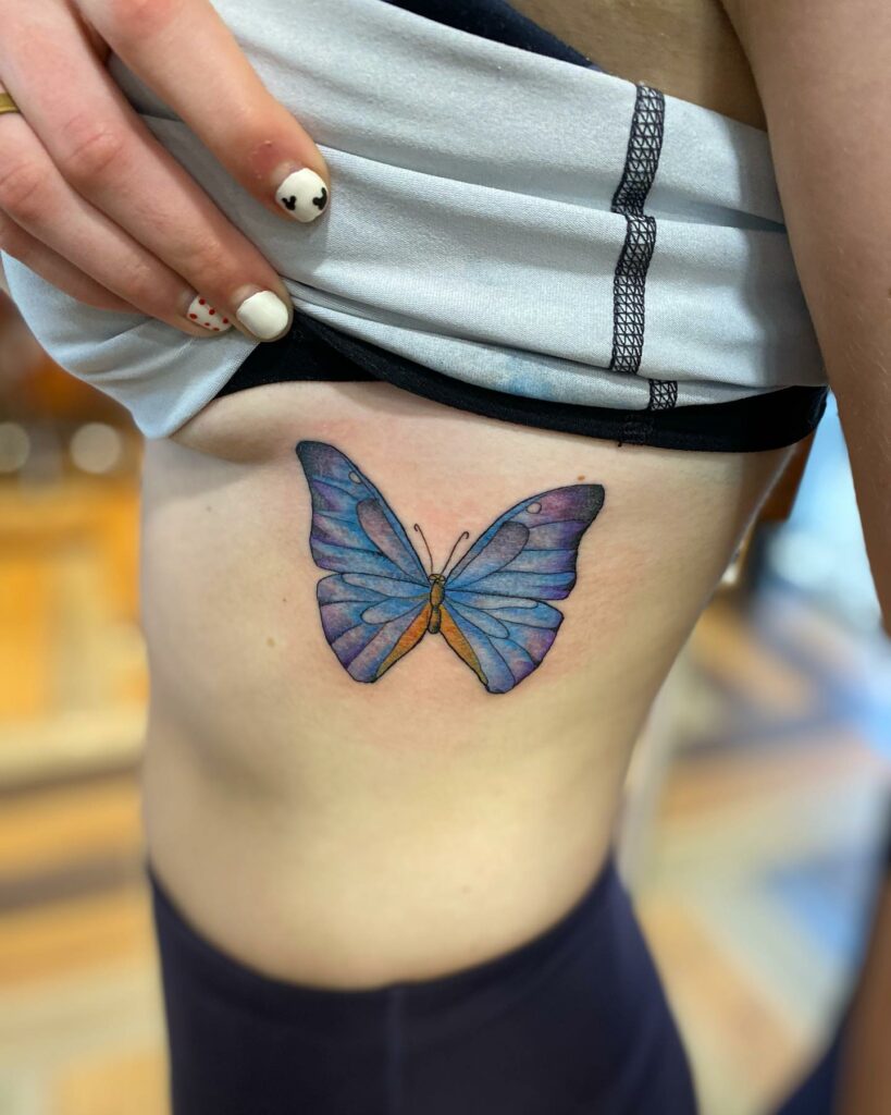 Single needle butterfly tattoo on the ribcage