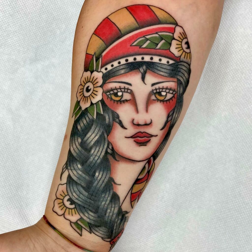Traditional style lady head tattoo on the upper arm