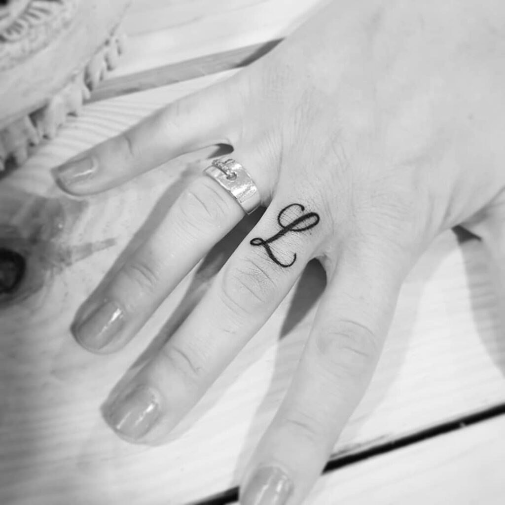 Cursive Lettering Initial Tattoo on Finger