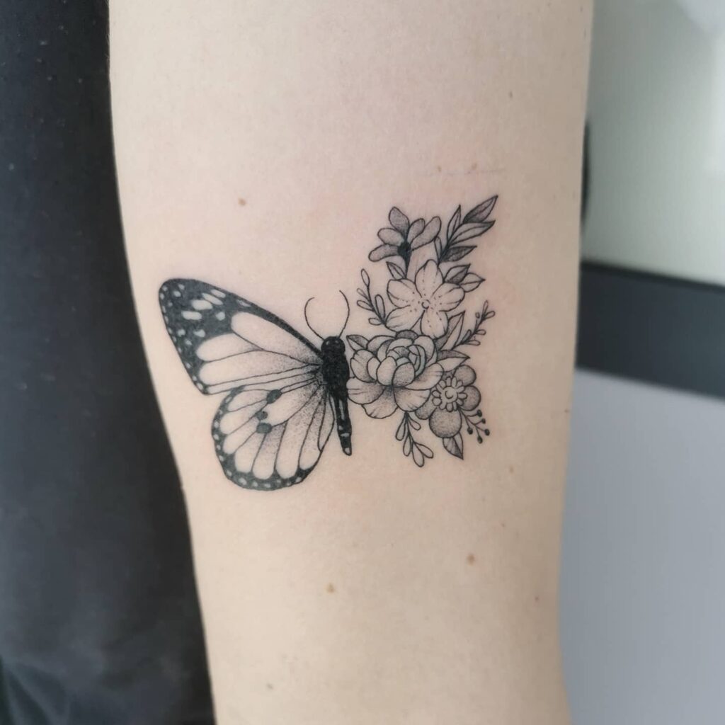 Fine line style half butterfly half flower tattoo