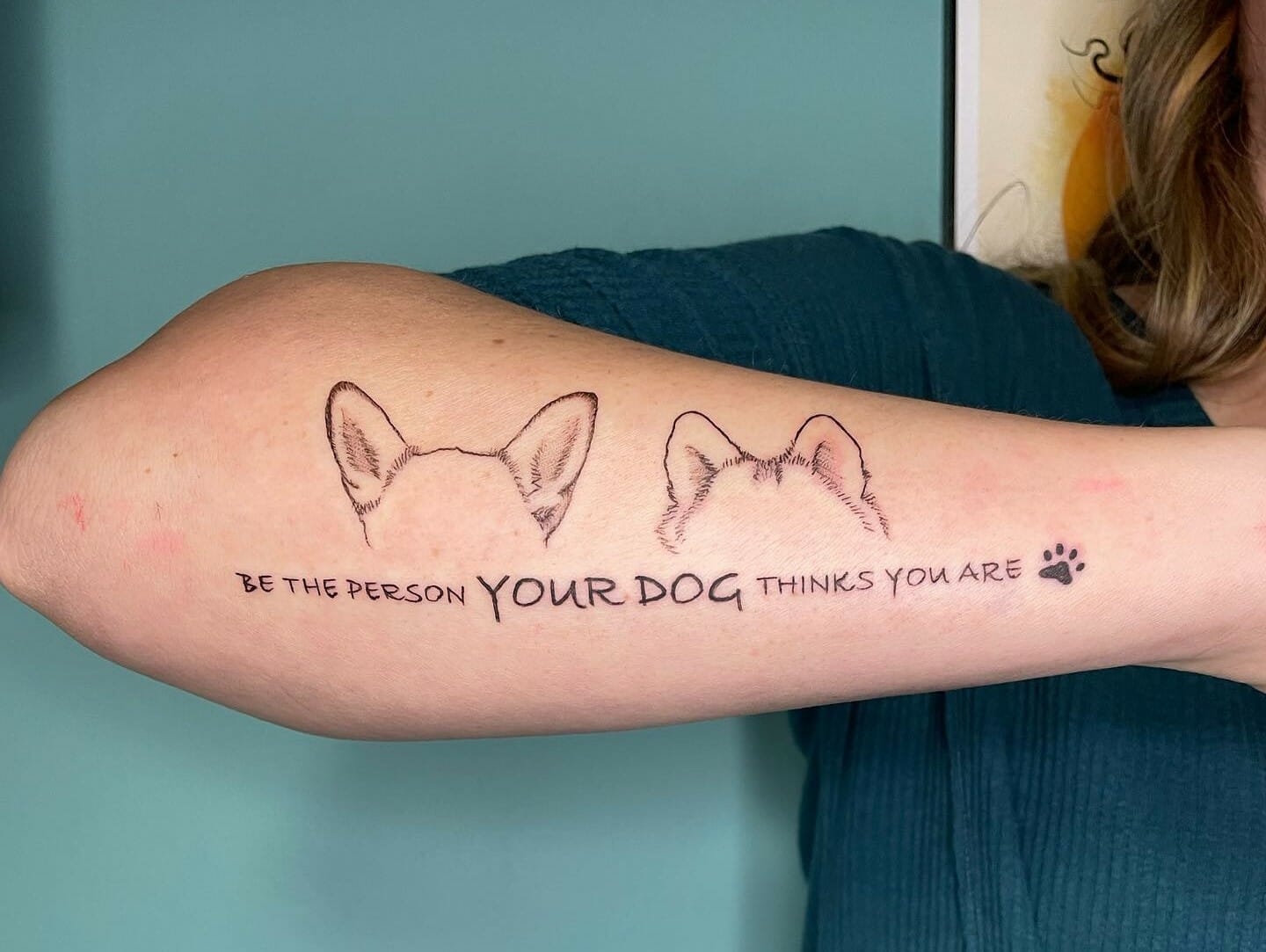 Minimalist dog ears tattoo placed on the inner forearm
