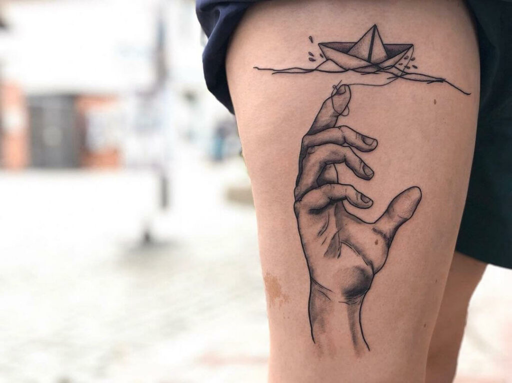 Hand And Paper Boat Tattoo