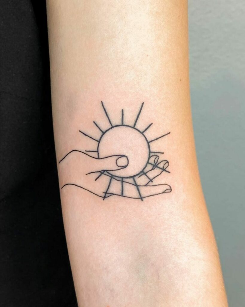 Hand Holding Simple Sun Tattoo