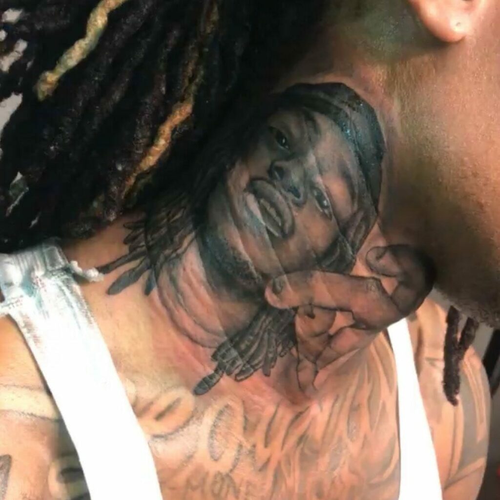 King Von With Twisted Hair And Tattoos On Hand And Neck Is Wearing