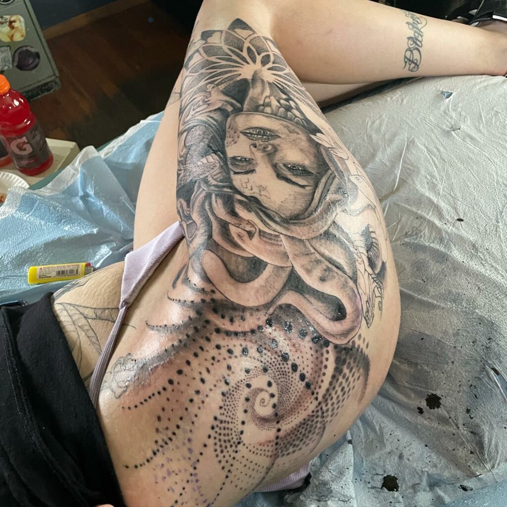 Medusa tattoo on the left thigh