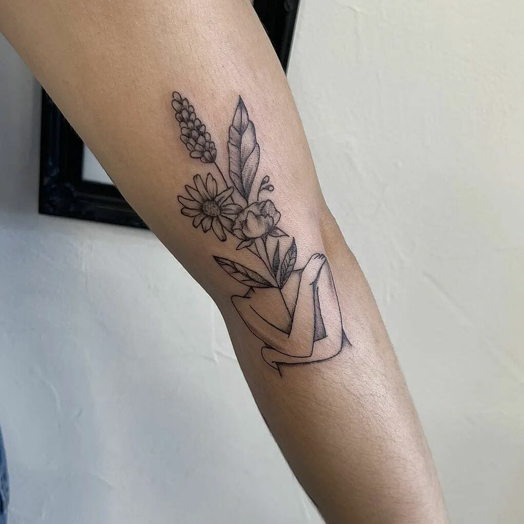 Self love  flower head woman tattoo on the tricep