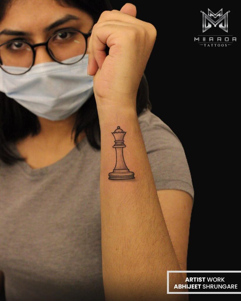 queen chess piece tattoo on wrist