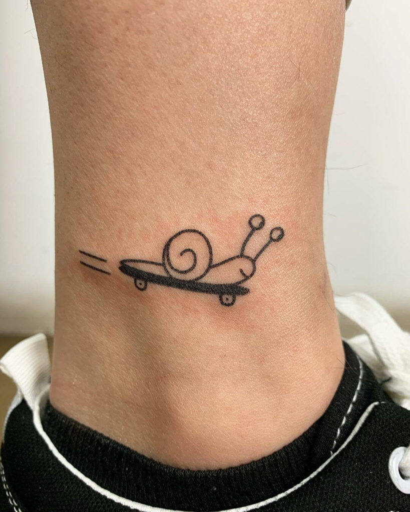 Microrealist snails tattooed on upper arm