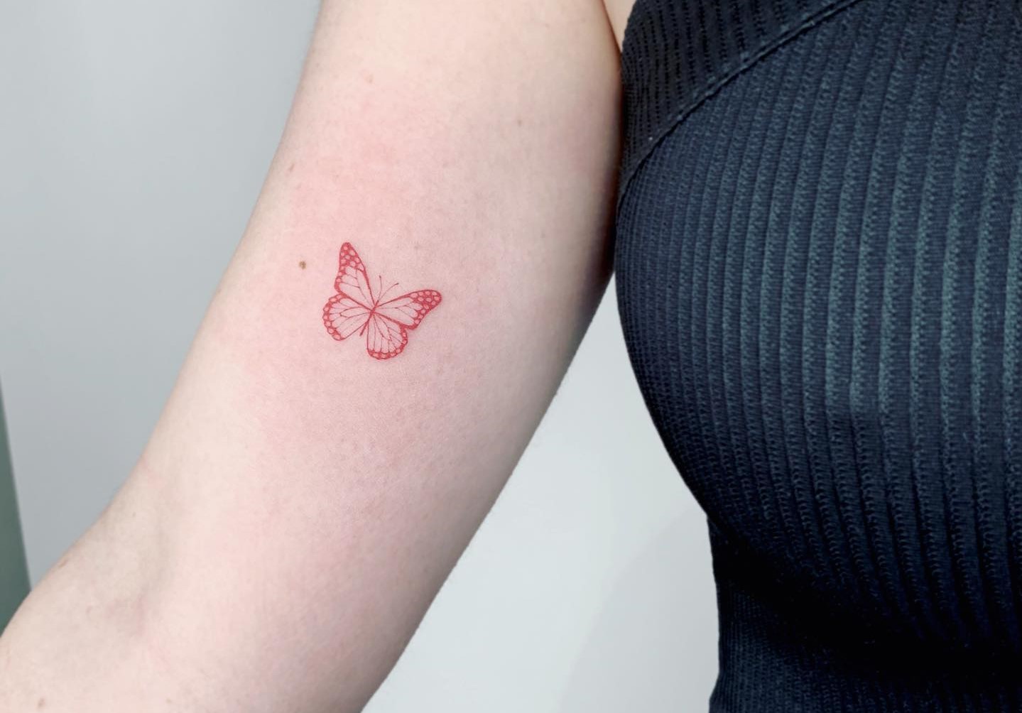 Single needle butterfly tattoo on the inner forearm