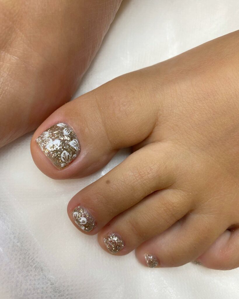 Sparkly Nail With Golden Glitters And White Flower