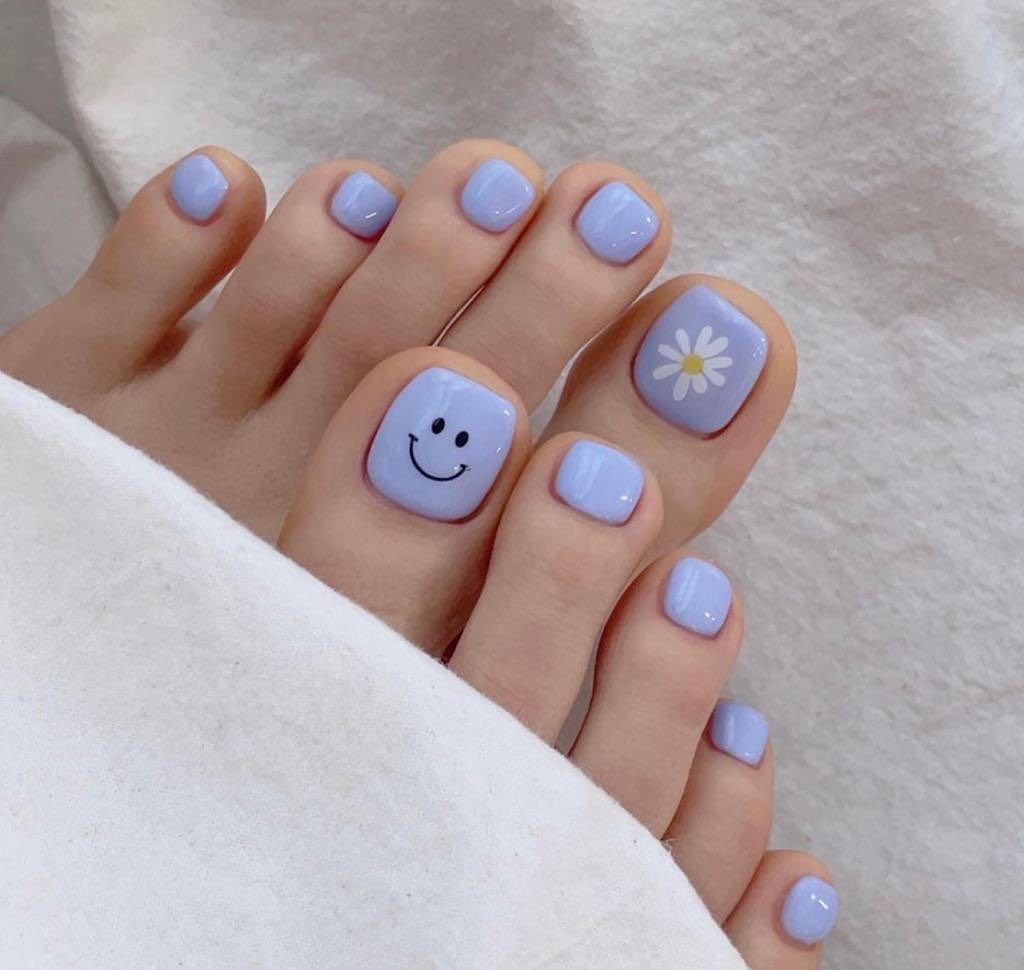 Light Blue Pedicure With Emoji and Flower Design