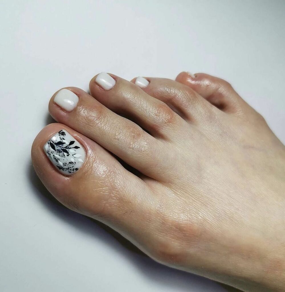 Milky White Pedicure With Black And White Leaves Design