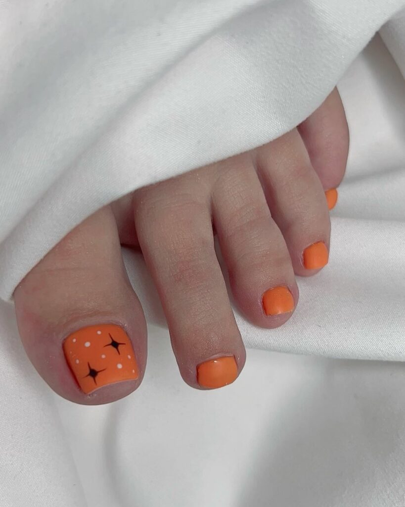 Matte Orange Pedicure With Stars Design