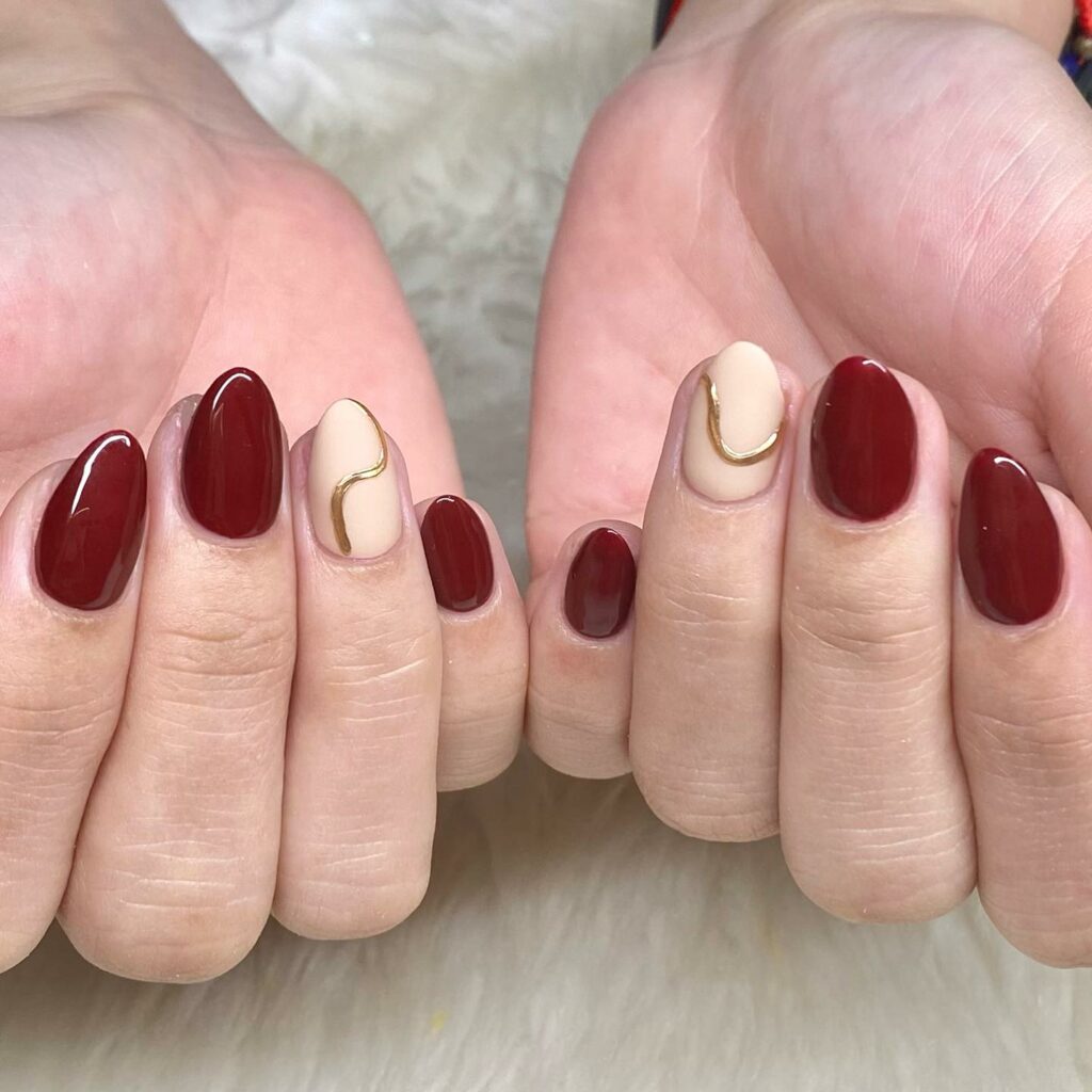 Burgundy Nails with Gold Swirl Accents