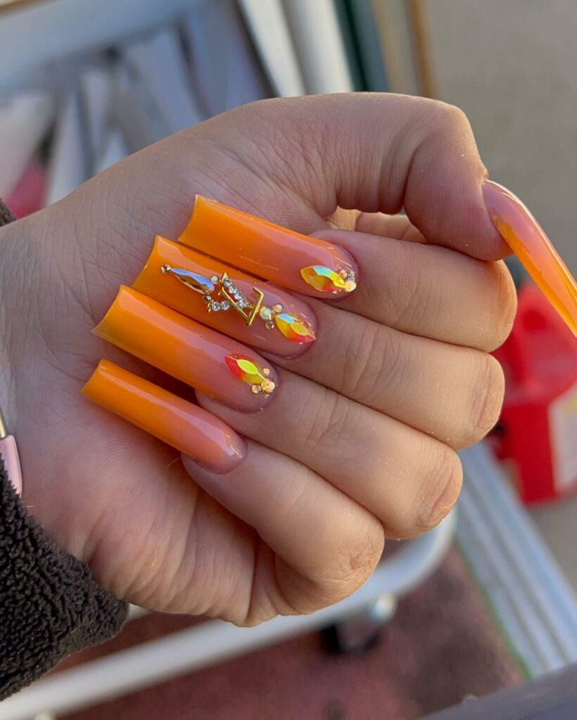 Sunset Orange Ombré Nails with Louis Vuitton Accents
