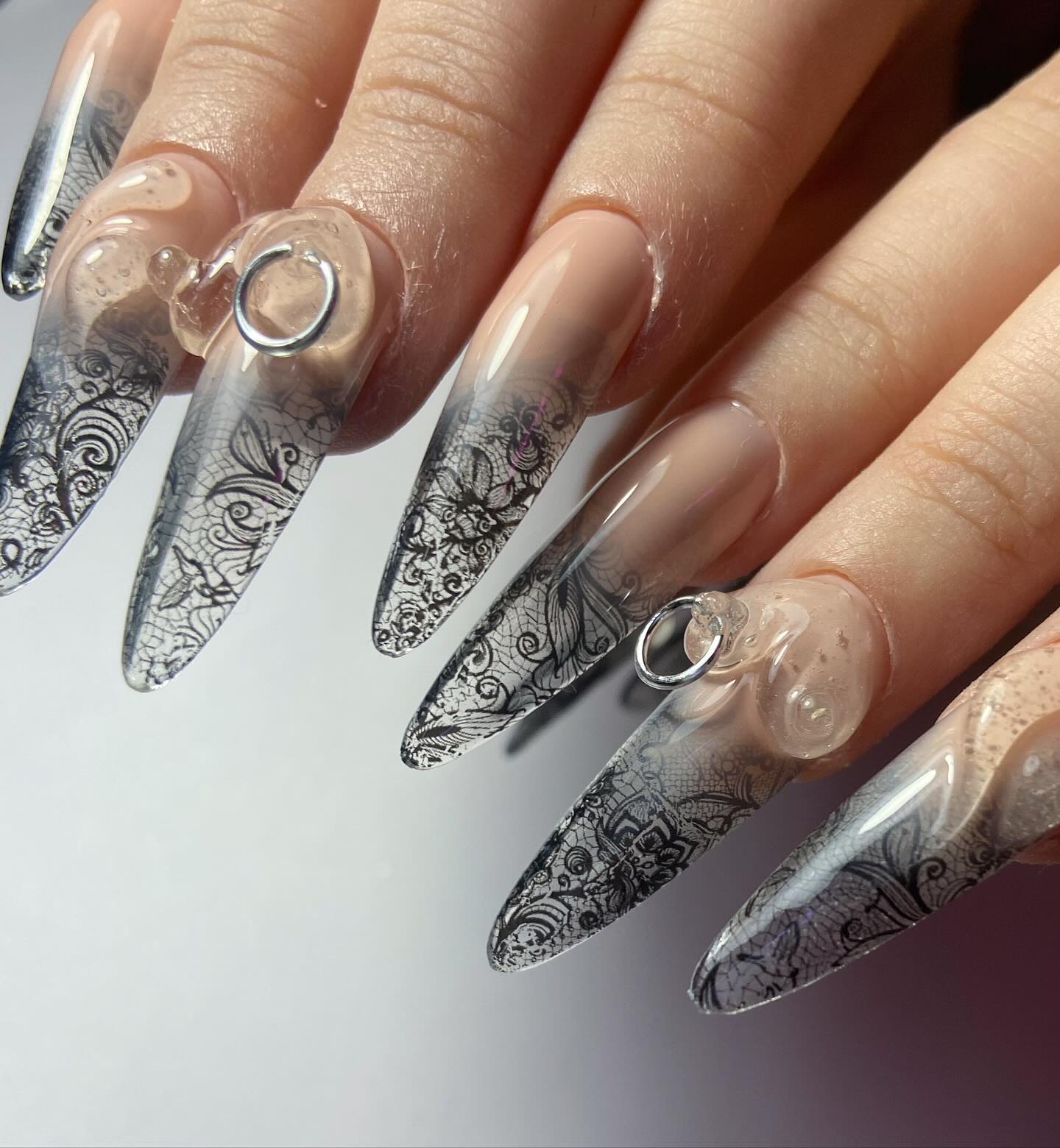 Elegant Lace Design on Stiletto Nails with Piercings